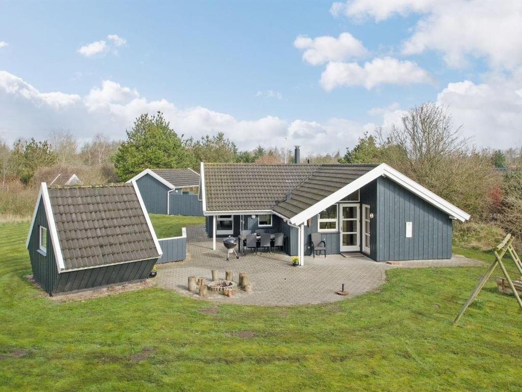 une maison avec un toit en pente et une terrasse dans l'établissement Holiday Home Aisa - all inclusive - 10-5km from the sea by Interhome, à Oksbøl