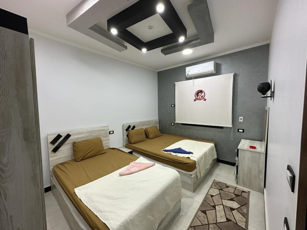 a room with two beds and a projection screen at واحة بكار in Bawiti