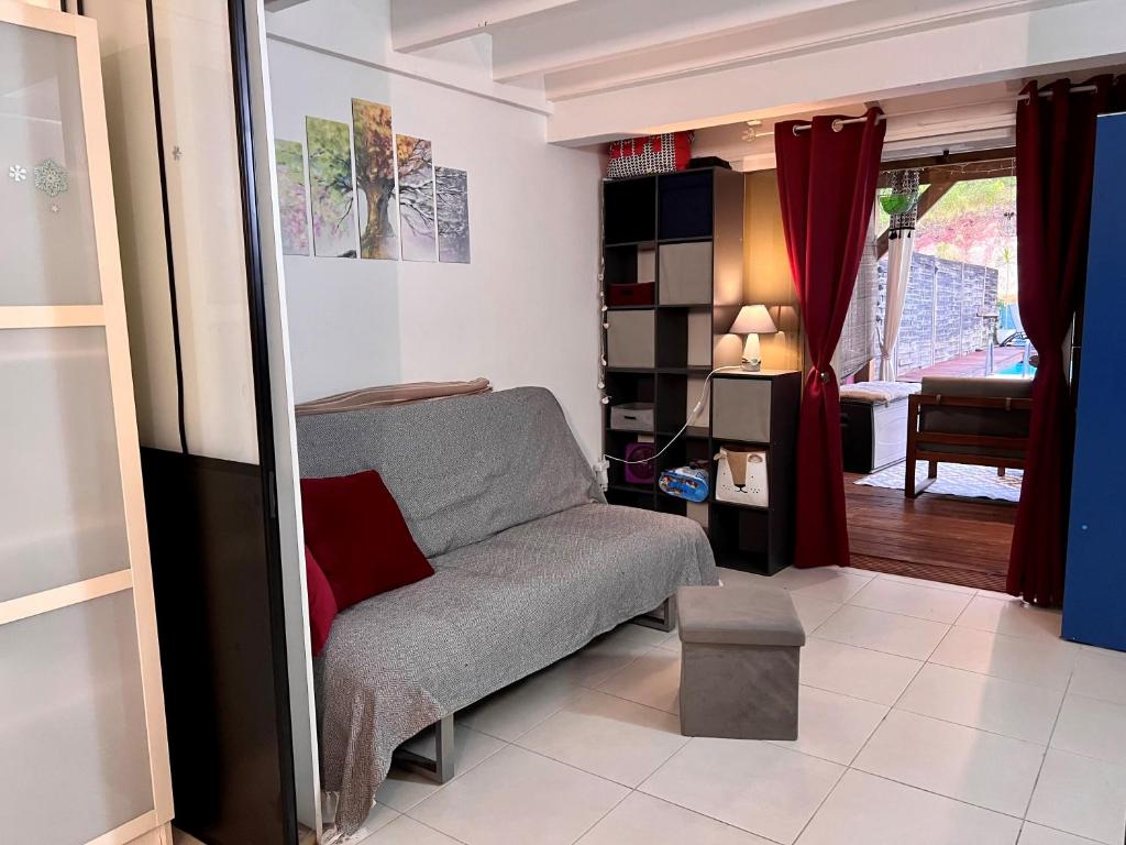 a living room with a couch and a table at Villa cosy, piscine et plage. in Les Trois-Îlets