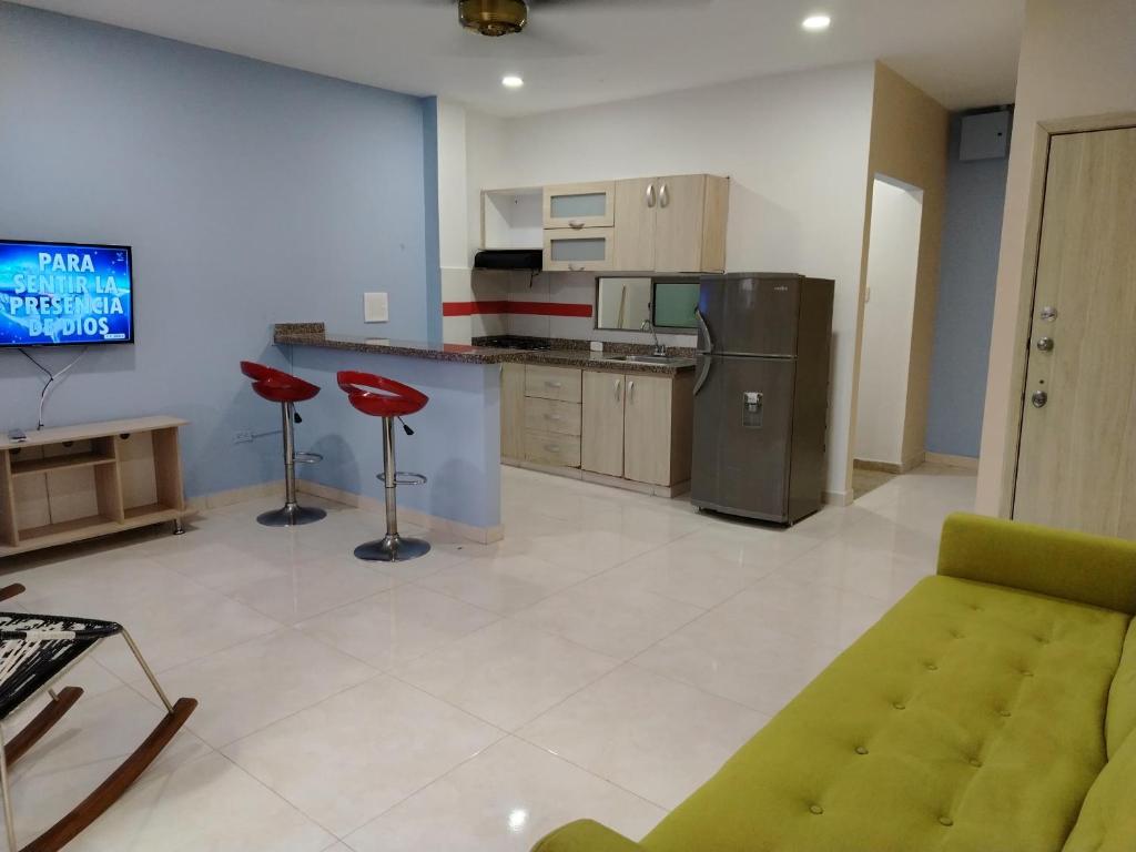 sala de estar con sofá y cocina en Oasis Olmos en Cereté