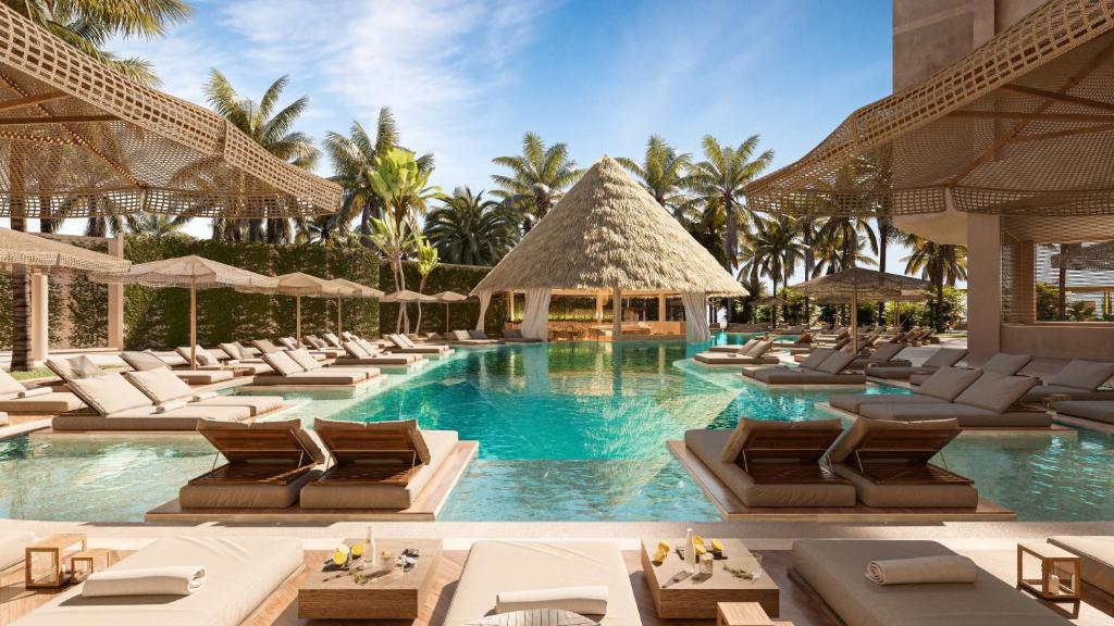 a pool at a resort with lounge chairs at Almare, a Luxury Collection Adult All-Inclusive Resort, Isla Mujeres in Isla Mujeres