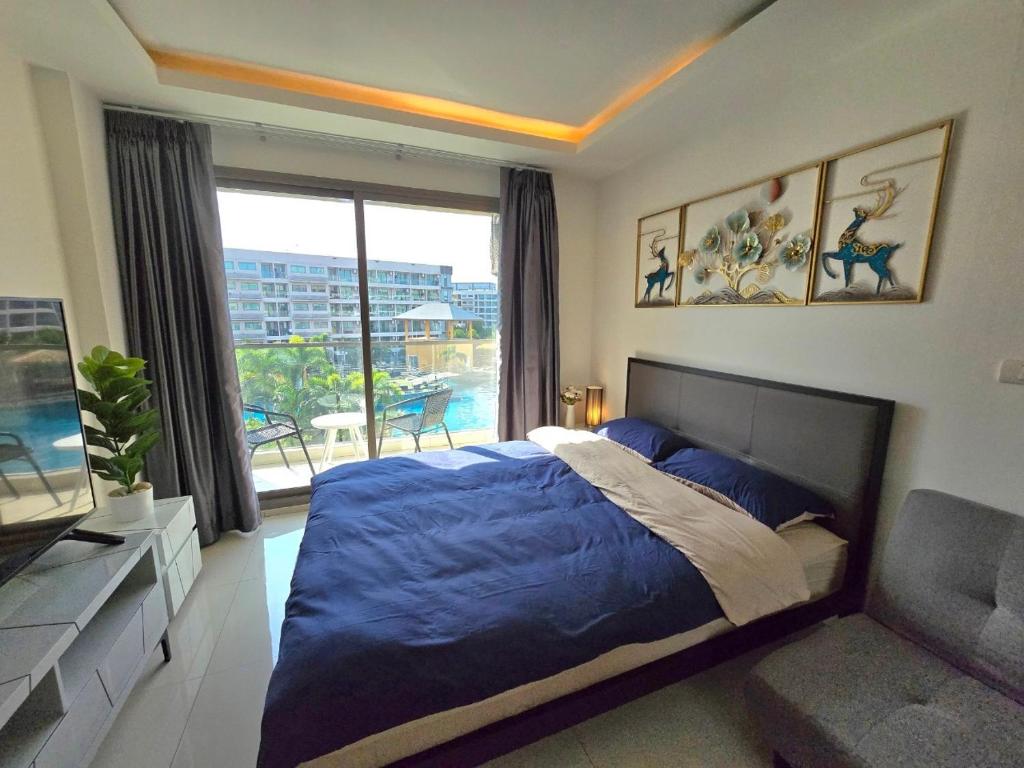 1 dormitorio con cama, sofá y ventana en Laguna beach condo resort 3 maldives pattaya top pool view ลากูน่า บีช คอนโด รีสอร์ต 3 พัทยา en Jomtien Beach