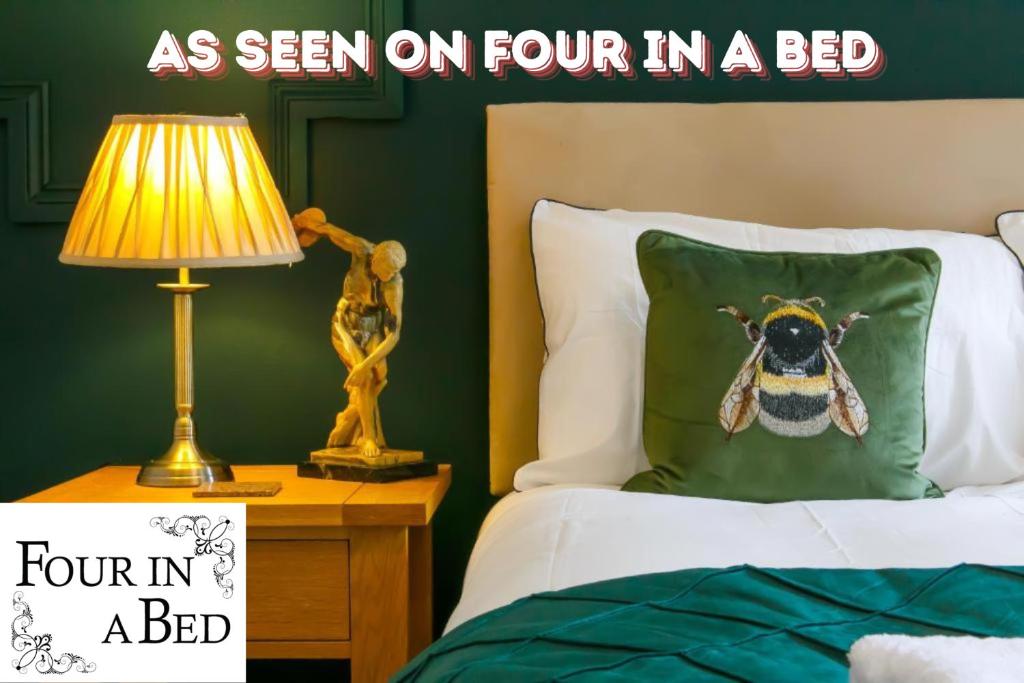 a bed with a pillow with a bumble bee on it at The Mayfield Apartments in Sunderland
