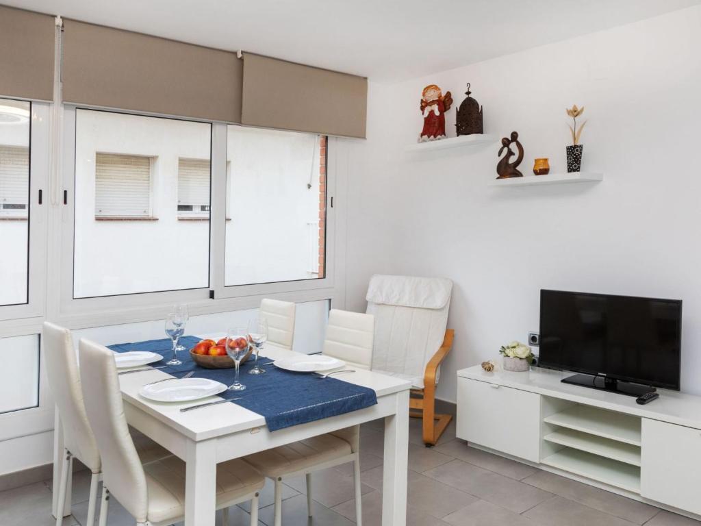 comedor blanco con mesa y TV en Apartment Pinos by Interhome, en Port de la Selva