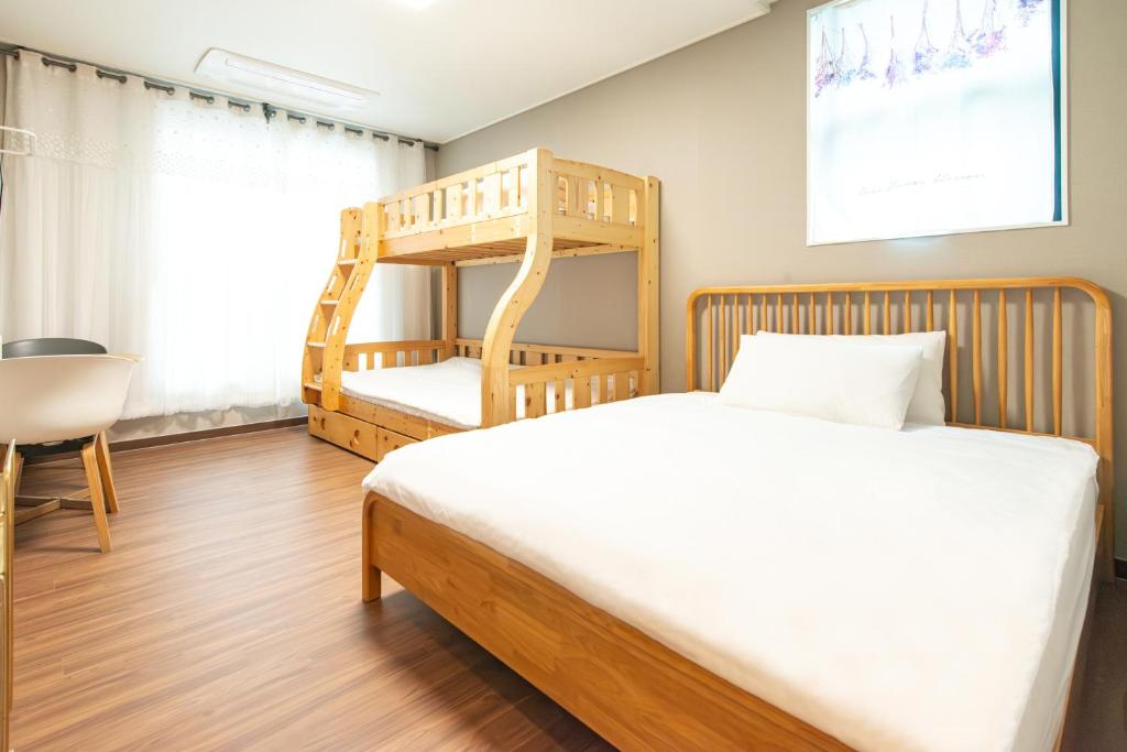 a bedroom with a bed and a wooden bunk bed at Incheon Airport Guest House King in Incheon