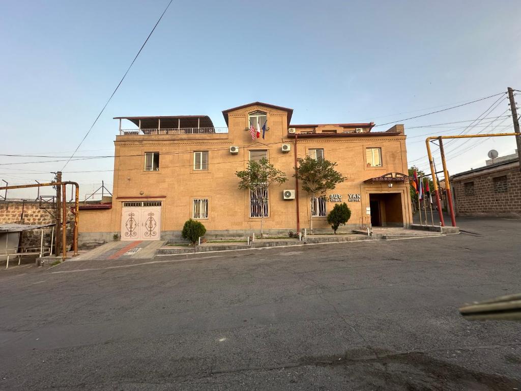 a large brick building sitting on the side of a street at YAN HOTEL in Yerevan