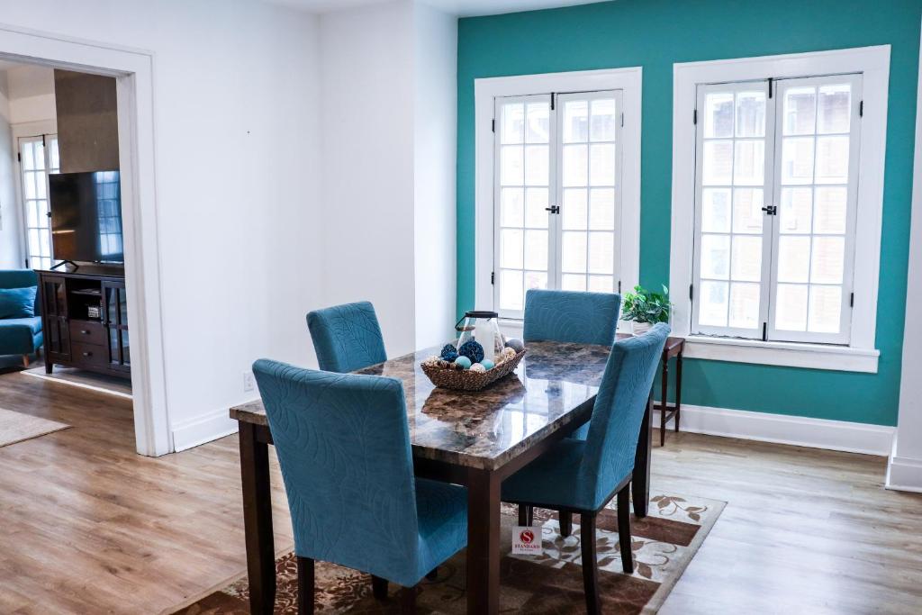 a dining room with a table and blue chairs at Downtown Retreat - 2BR Oasis with Parking in Columbus
