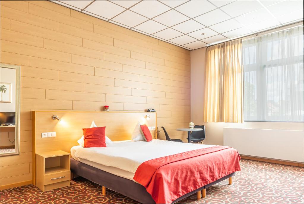- une chambre d'hôtel avec un lit et une baignoire dans l'établissement Hotel - Brasserie Ingredi, à Brée