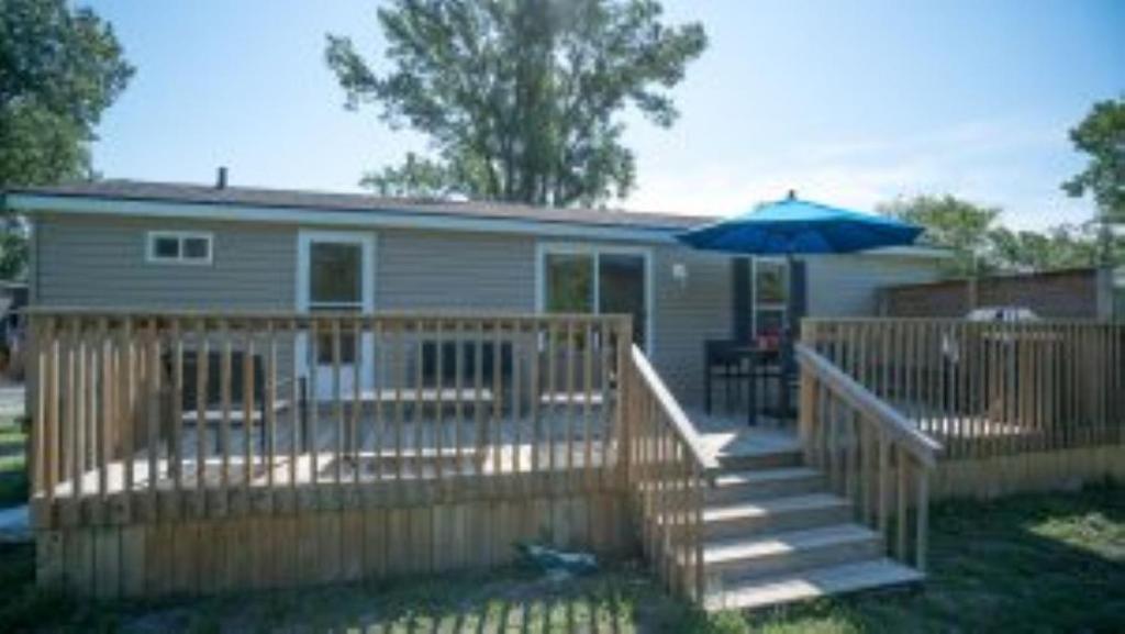 a house with a deck and an umbrella at 3 Bedroom Cottage Dragon Fly Drive 7 in Cherry Valley