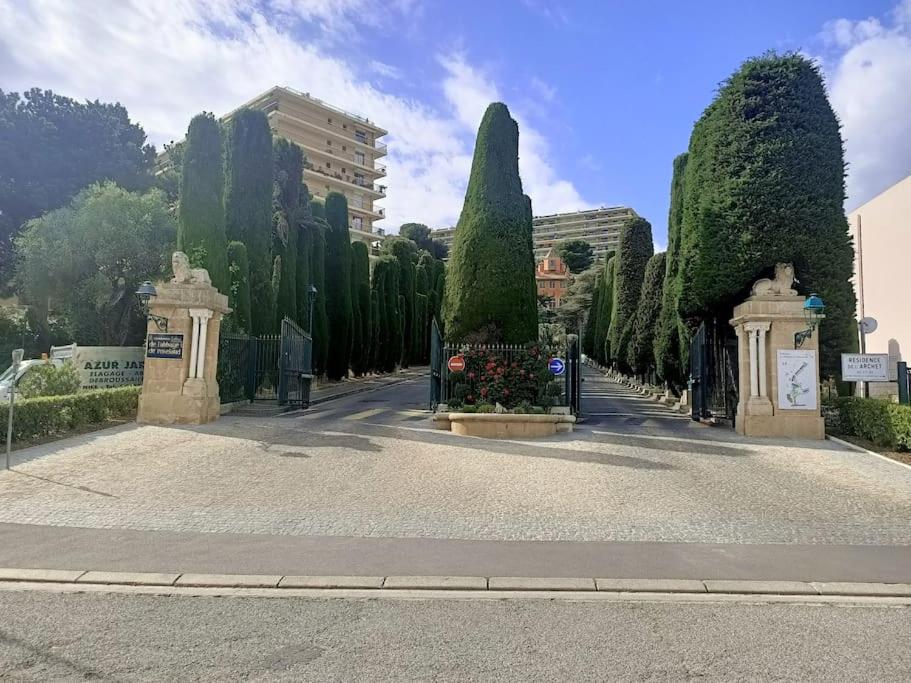 a street with a gate and trees and a building at L'abbaye Luxe et Vue Panoramique in Nice