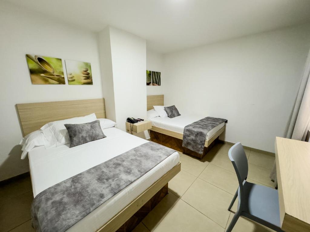 Postel nebo postele na pokoji v ubytování Hotel Alcaravan Medellín