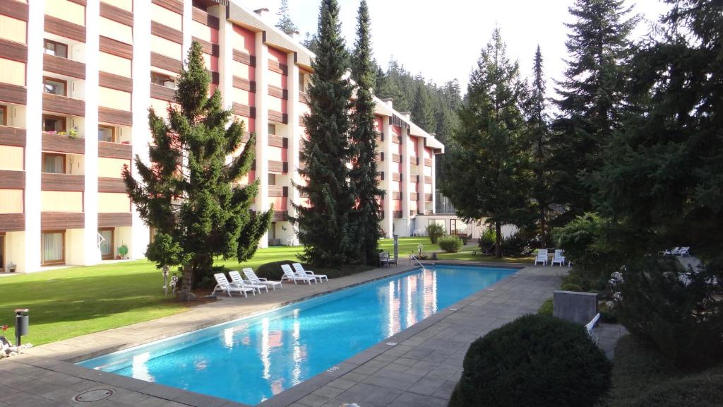 a swimming pool in front of a building at Rancho Apartment in Laax