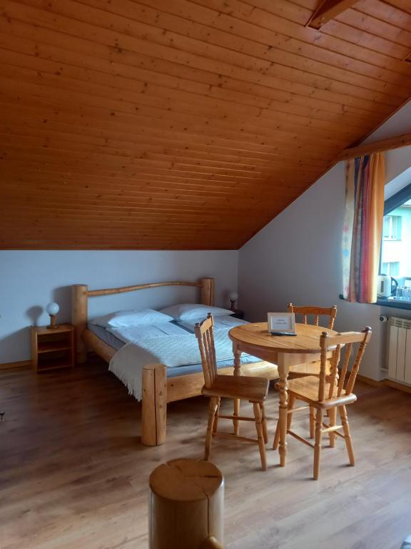 - une chambre avec un lit, une table et des chaises dans l'établissement Na Brzegu, à Szczyrk