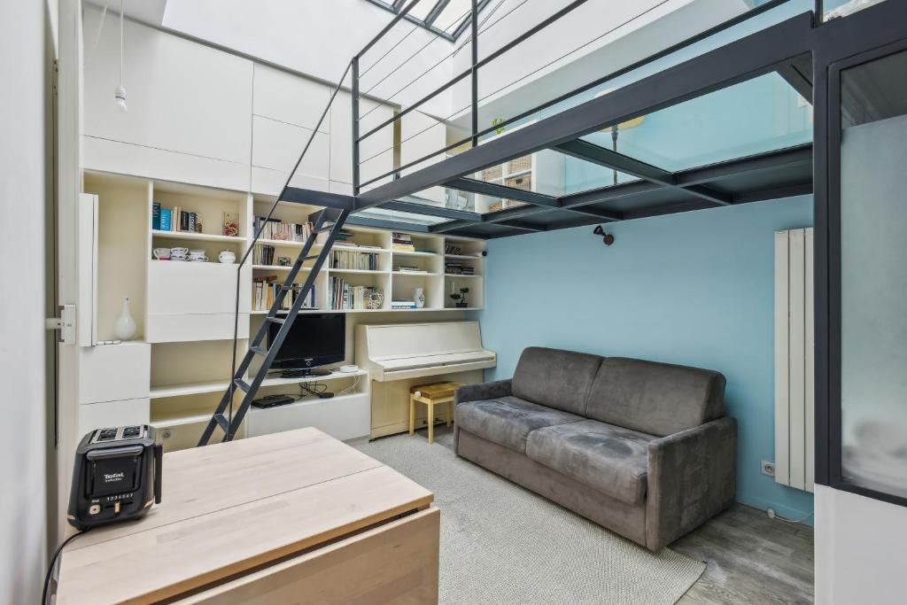 un salon avec un canapé et un bureau dans l'établissement Atypique Loft 3 personnes with AC by Weekome, à Paris