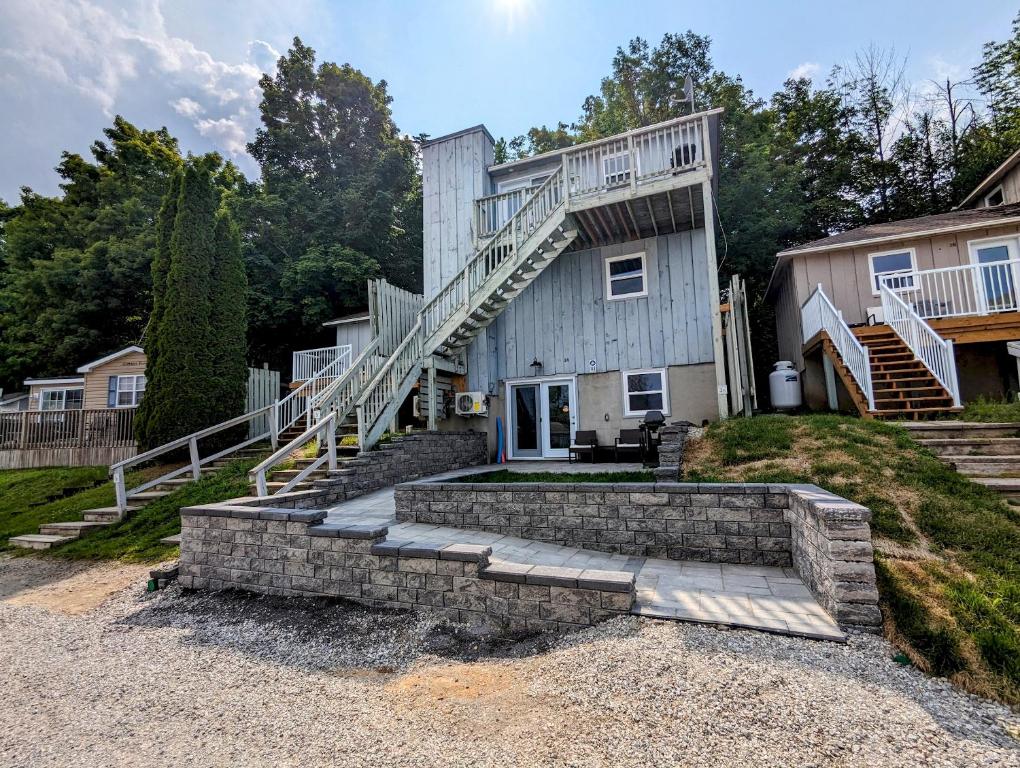a house with a staircase on the side of it at Newly Renovated 2 Bedroom Beach Front Condo 3C in Lanark