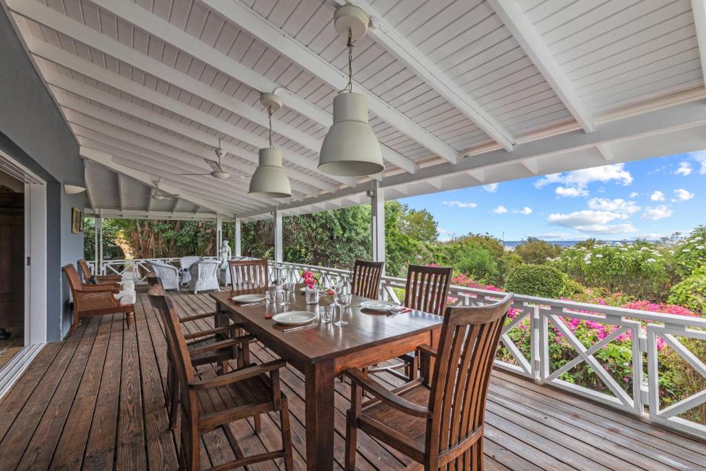 a dining room with a table and chairs on a deck at Villa Papaya in Willemstad