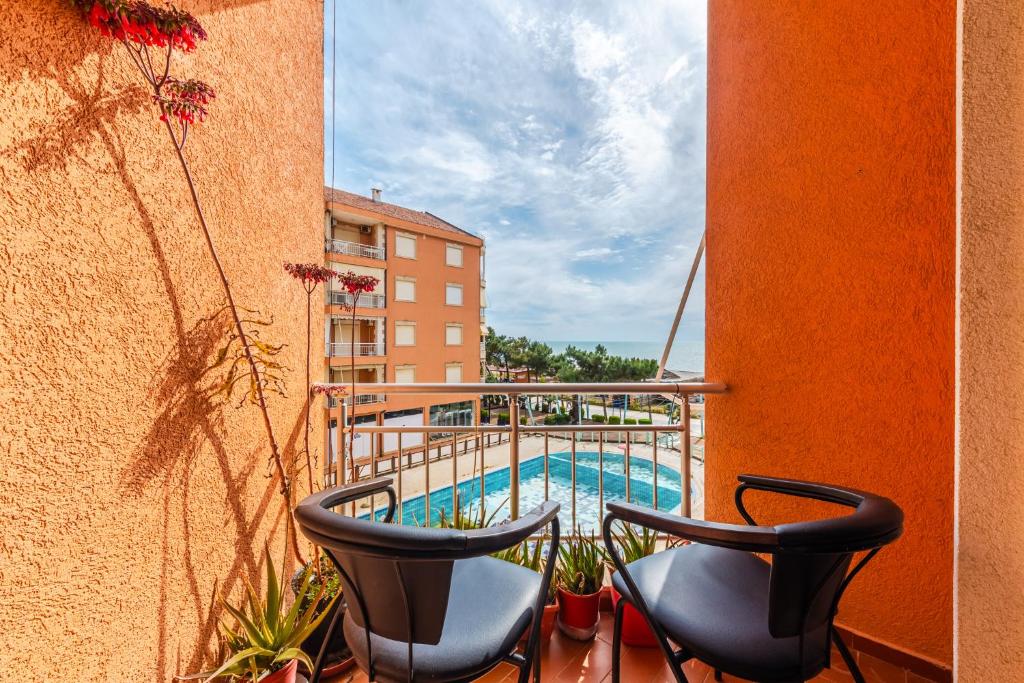 balcone con 2 sedie e piscina di Orange Beachfront Studio by PS a Golem
