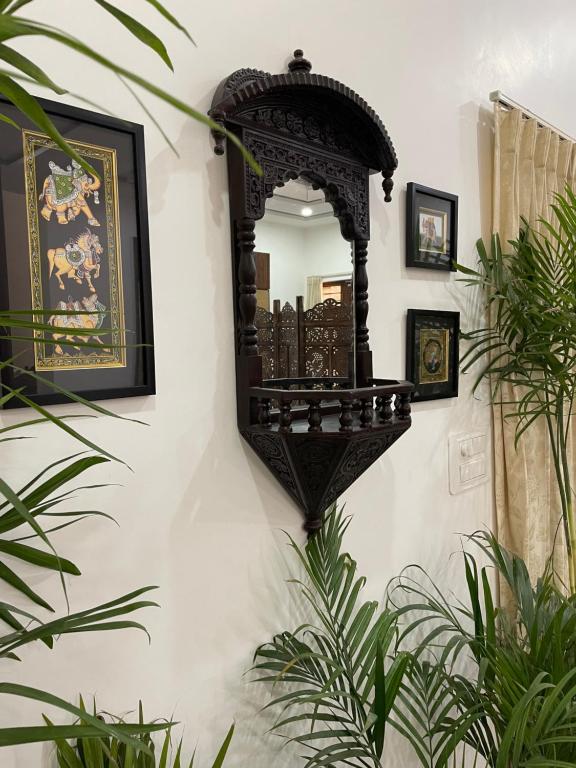 a mirror on the side of a wall with plants at Karni Nivvas - Luxury Redefined in Udaipur