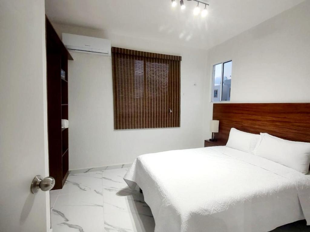 - une chambre avec un lit blanc et une fenêtre dans l'établissement Departamento en tulum Quintana roo, à Tulum