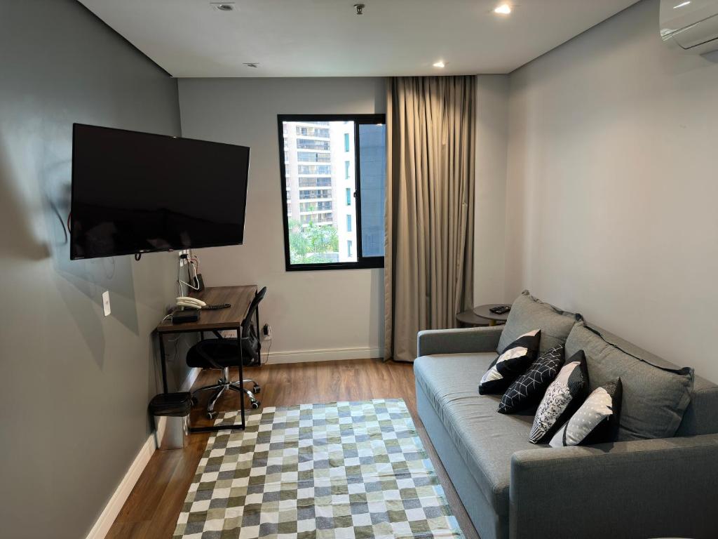 a living room with a couch and a flat screen tv at Flat- mercure c/ quarto, sala e coz - Moema in São Paulo