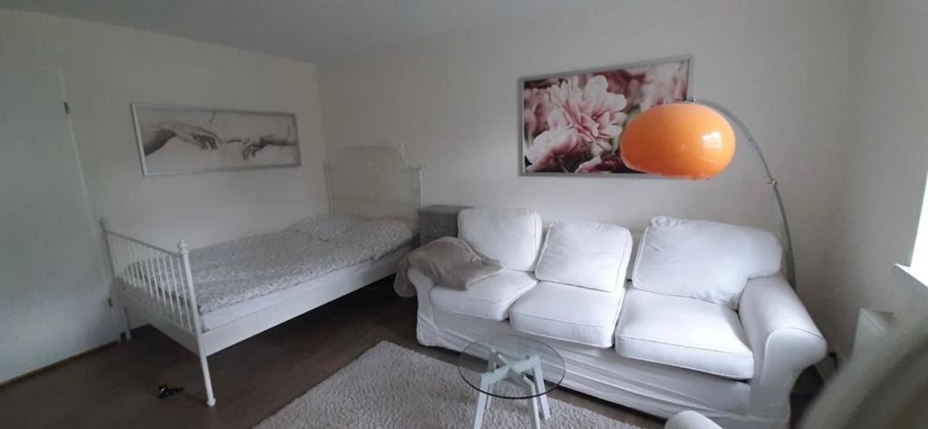 a living room with a white couch and a bed at Ferienwohnung An der Fangschleuse in Fangschleuse