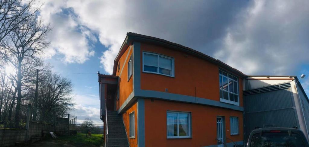 an orange building with a sky in the background at Casa Aricel in Chantada