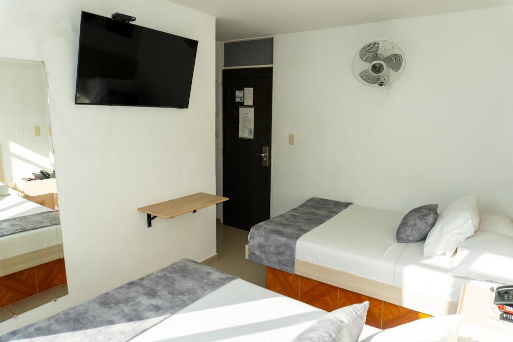 Postel nebo postele na pokoji v ubytování Hotel Alcaravan Medellín