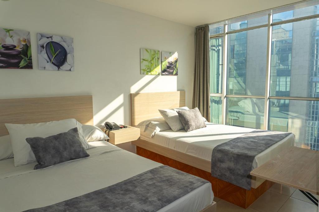Postel nebo postele na pokoji v ubytování Hotel Alcaravan Medellín