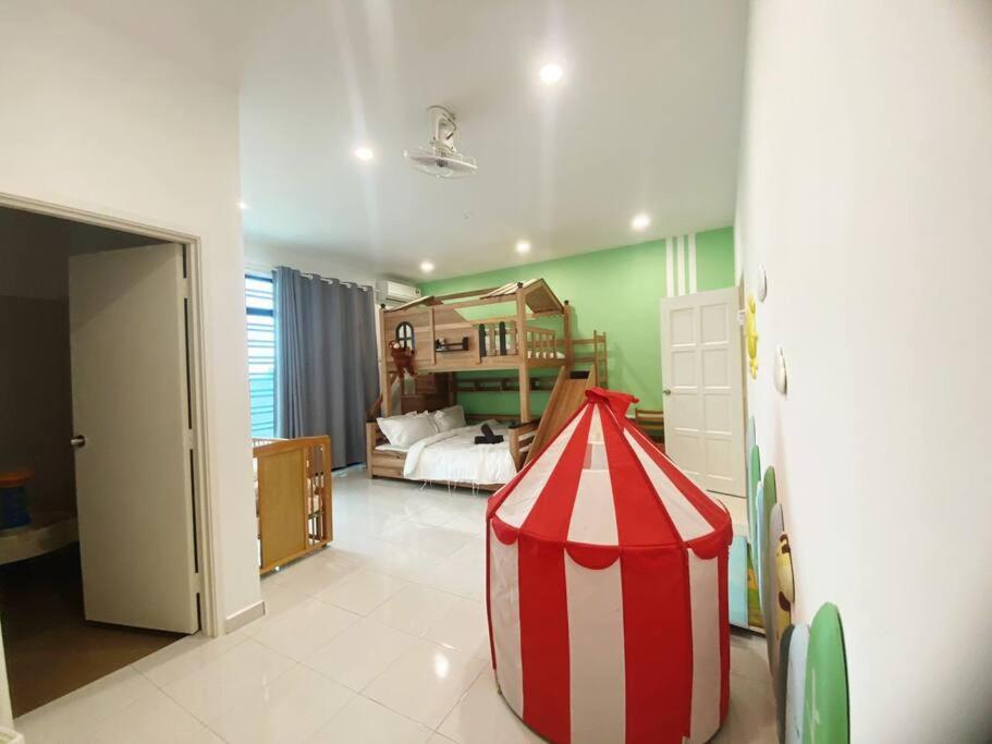 Habitación con cama y tienda de campaña en rojo y blanco en PlayHouse Fun4Kids 22pax 6R5B, en Melaka