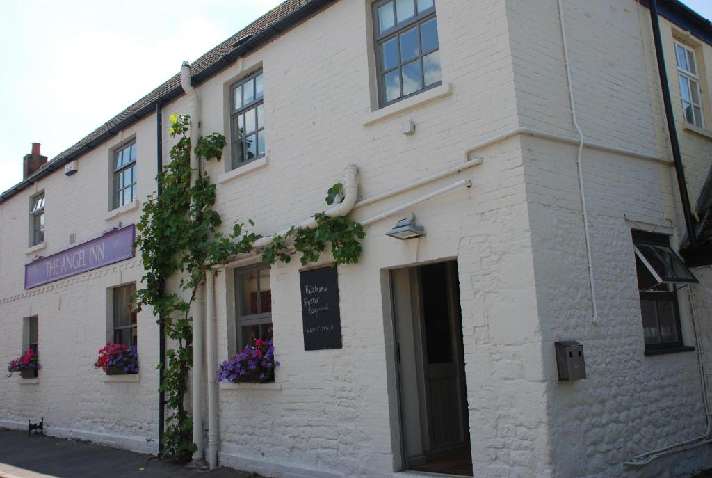 a white building with flowers on the side of it at The Angel Inn in Warminster