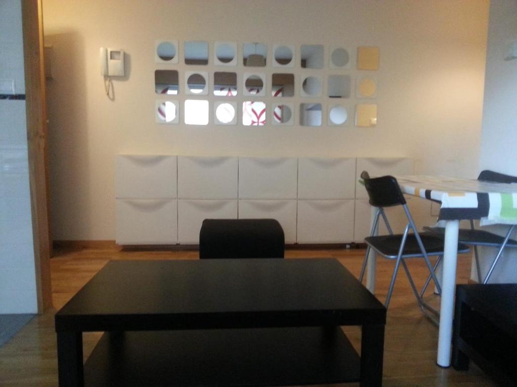 une table et des chaises dans une pièce avec un mur dans l'établissement Picasso, à Culleredo