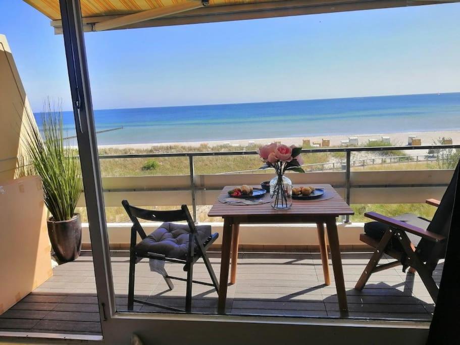 a table on a balcony with a view of the beach at Ferienwohnung mit traumhaften Meerblick in Großenbrode