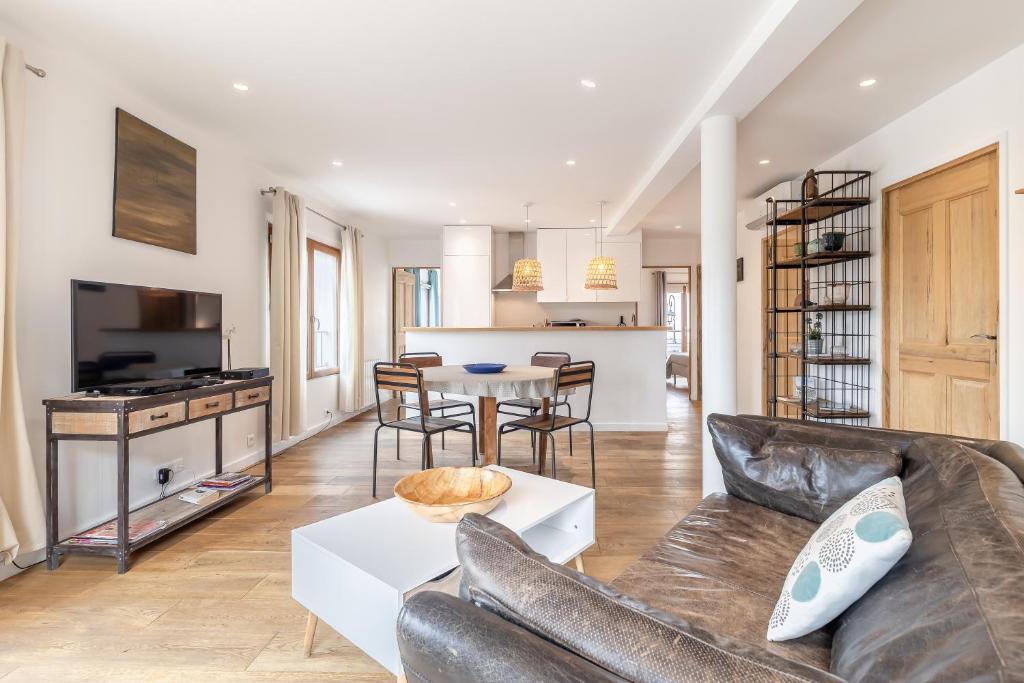 een woonkamer met een bank en een tafel bij Raisin- appartement familial donnant sur la Sorgue in LʼIsle-sur-la-Sorgue