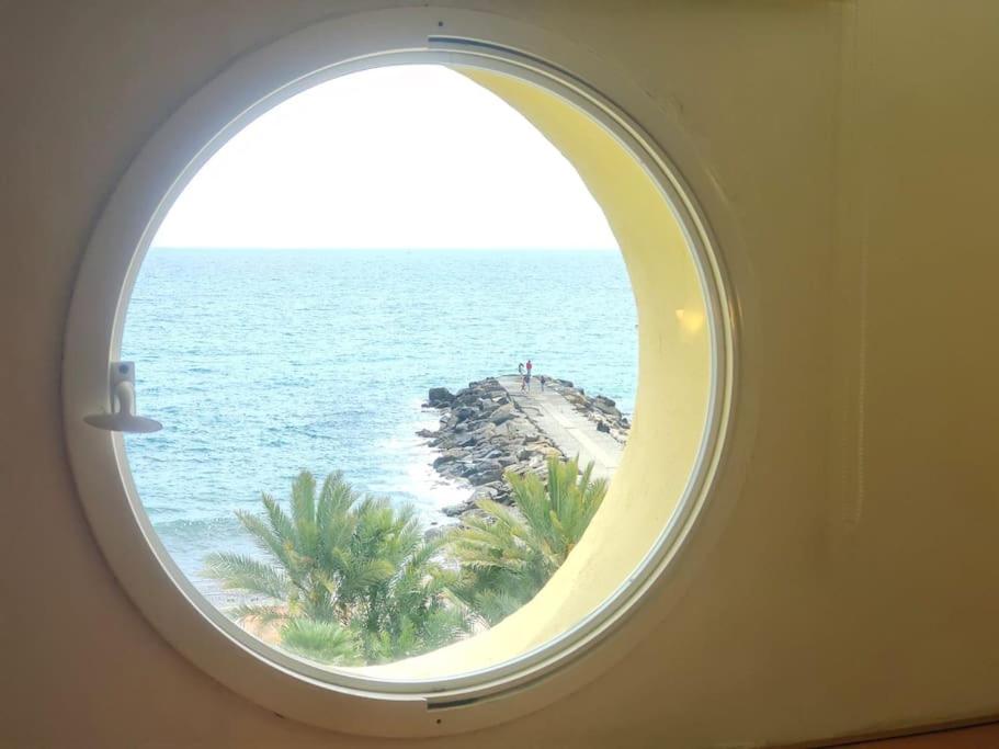janela anoréola num quarto com vista para o oceano em Appartamento-Oblò sul Mare em Sanremo