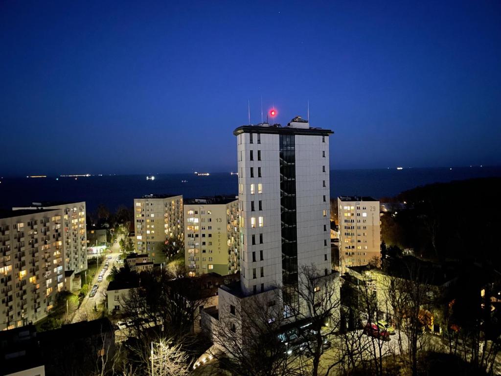 a tall building with a red light on top of it at Gdynia Riviera Hills in Gdynia