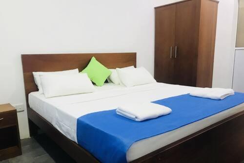 1 dormitorio con 1 cama grande y 2 toallas. en Fernando viila, en Wadduwa