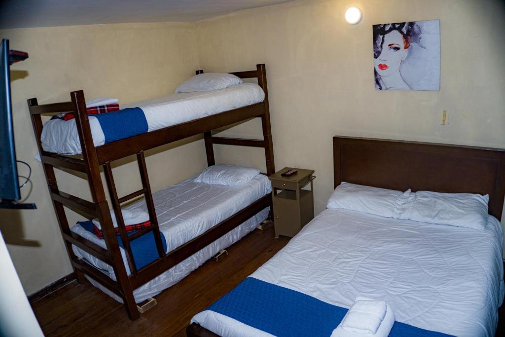 a bedroom with two bunk beds and a bed at By Cao Rest House in Bogotá