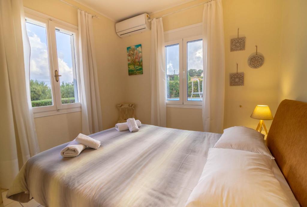 a bedroom with a large bed with towels on it at Kroussos Cottage in Faraklata