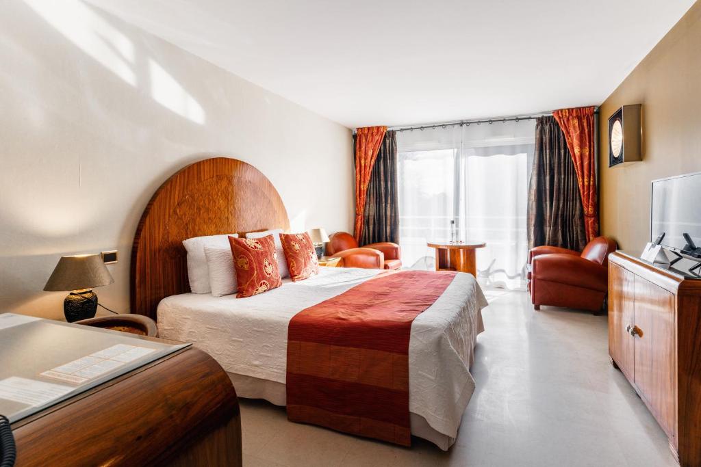 a hotel room with a bed and a couch at Logis L'Auberge - Maison Glenn Anna in Sainte Anne d'Auray