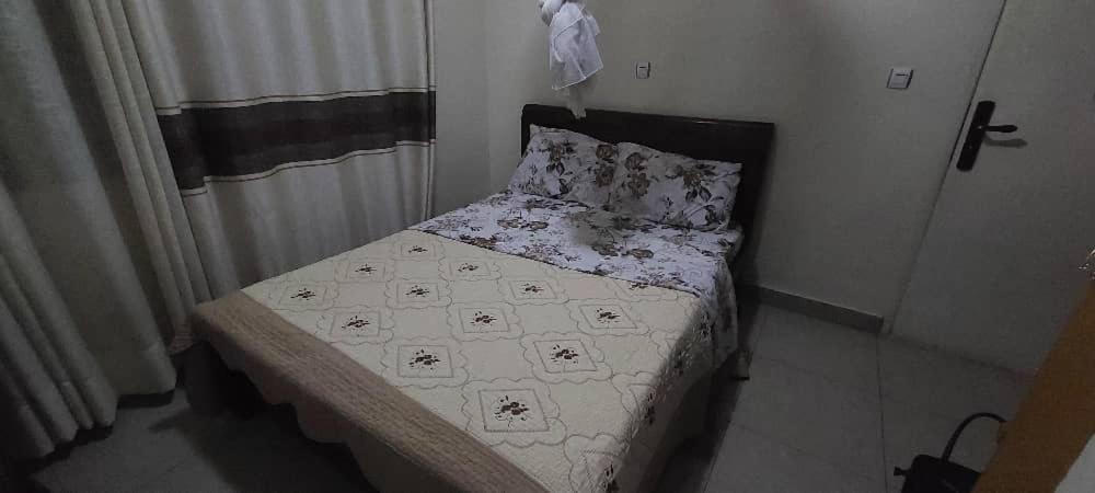a small bed in a small room with at Home sweet home in Kigali