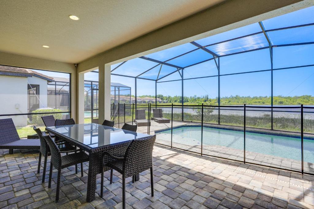 a patio with a table and chairs and a pool at Near Disney and Legoland Spacious Poolside Oasis! in Haines City