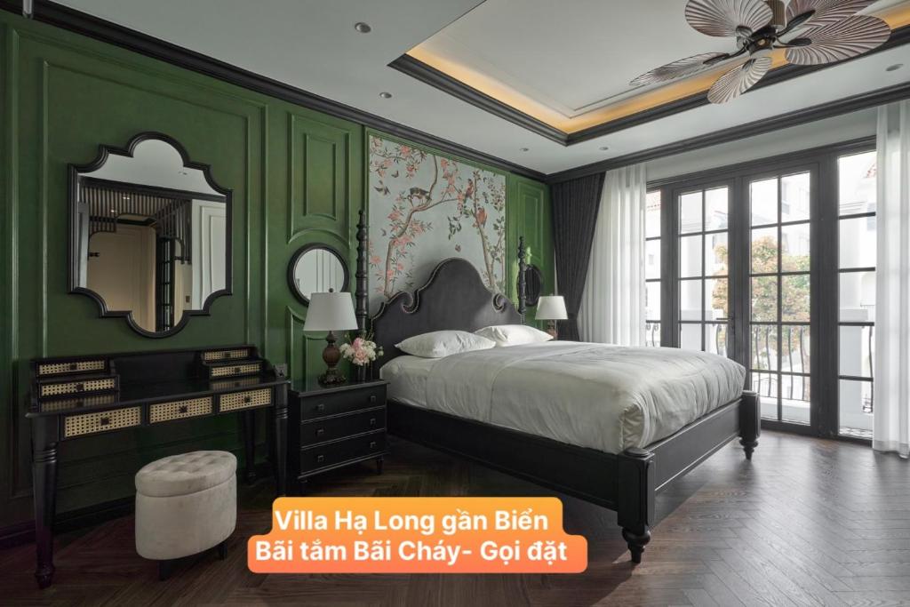 1 dormitorio con paredes verdes y 1 cama con espejo en Villa Hạ Long Gần Biển en Ha Long