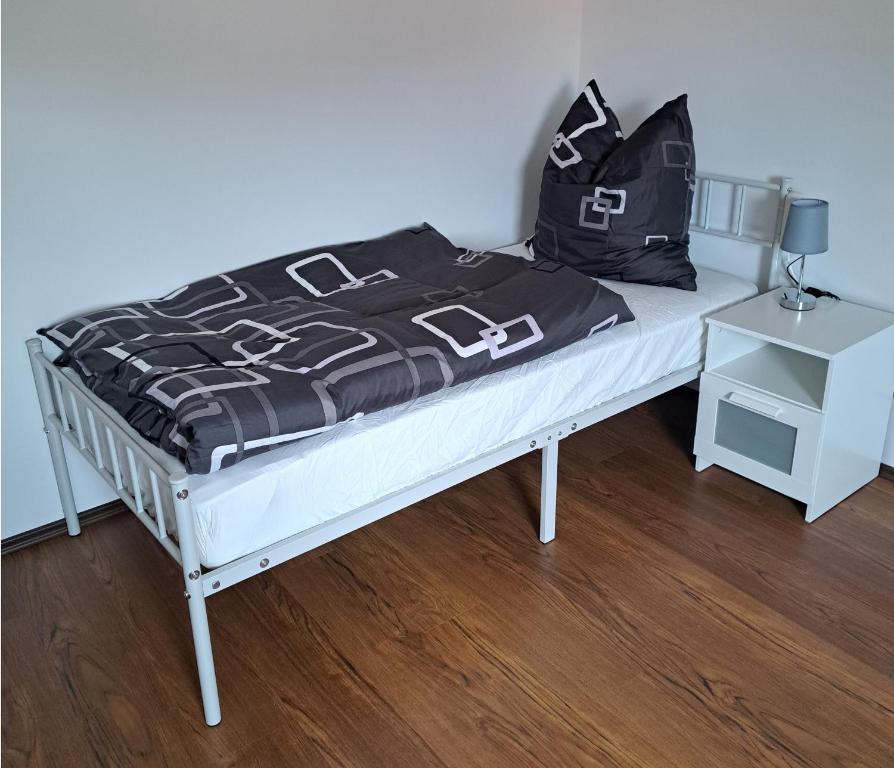 a bed with a black and white comforter on it at Ferienwohnung Paulus in Albstadt