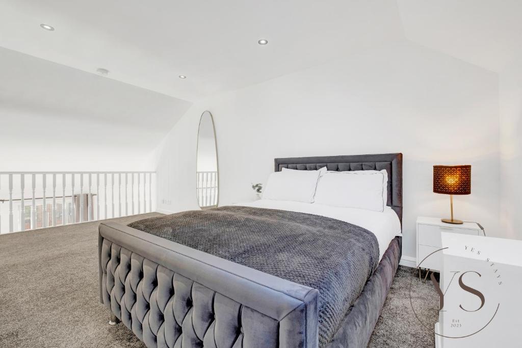 a white bedroom with a large bed and a lamp at Stylish Studio 5 - City Centre Coach Station in Birmingham