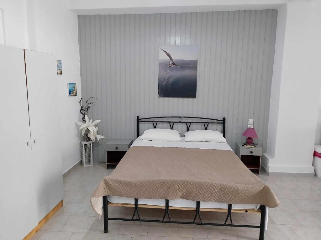 Studio George - near the beach في ماتالا: غرفة نوم بسرير وطائر على الحائط
