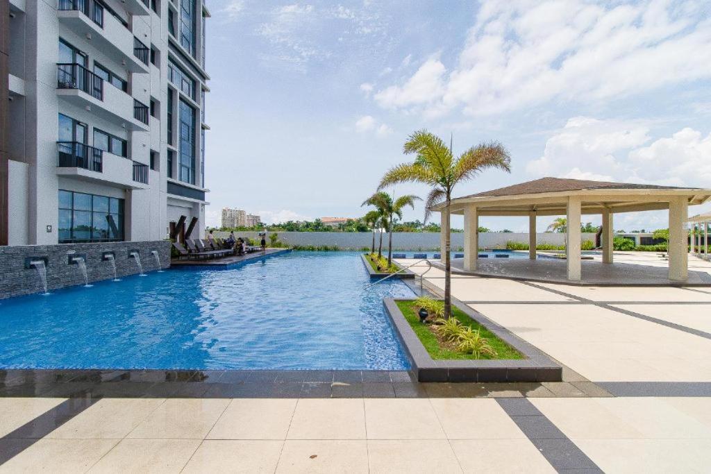 a swimming pool with a gazebo next to a building at Relaxing SEA VIEW condo Mactan Newtown in Punta Engaño