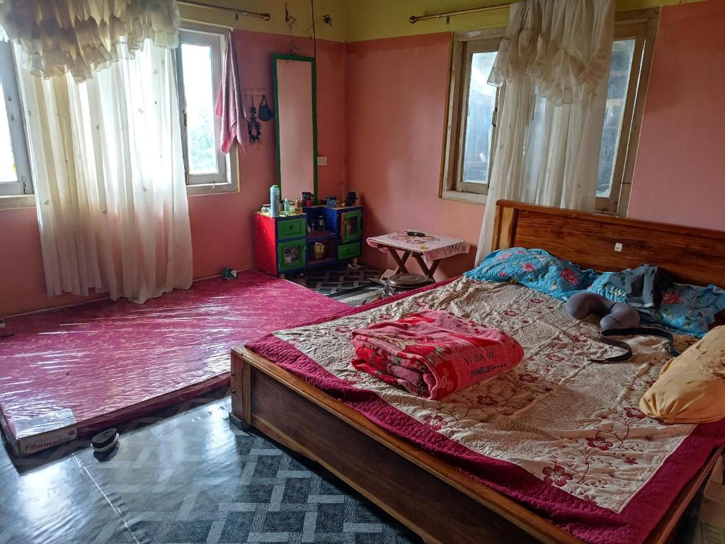K Swu Homestay في Kohīma: غرفة نوم بسرير في غرفة بجدران وردية