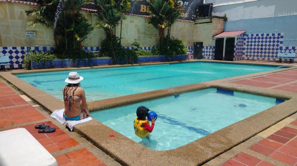 uma mulher e uma criança brincando na piscina em Hotel Descanso Inn Villavicencio em Villavicencio