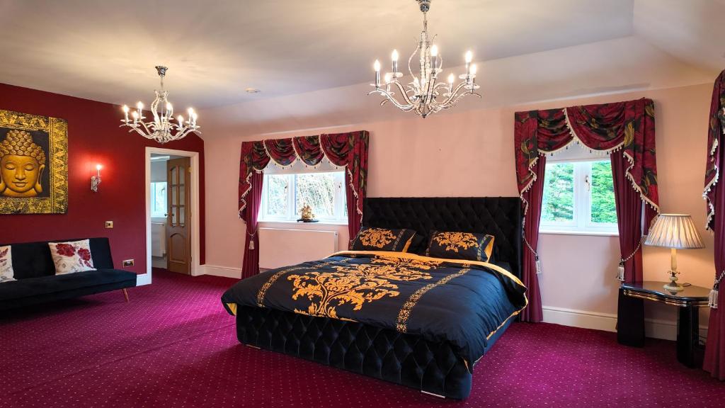 a bedroom with a bed and a chandelier at Stratford-upon-Avon 4BR Family Mansion on 1 acre with Pool, Gym & BBQ! in Henley in Arden