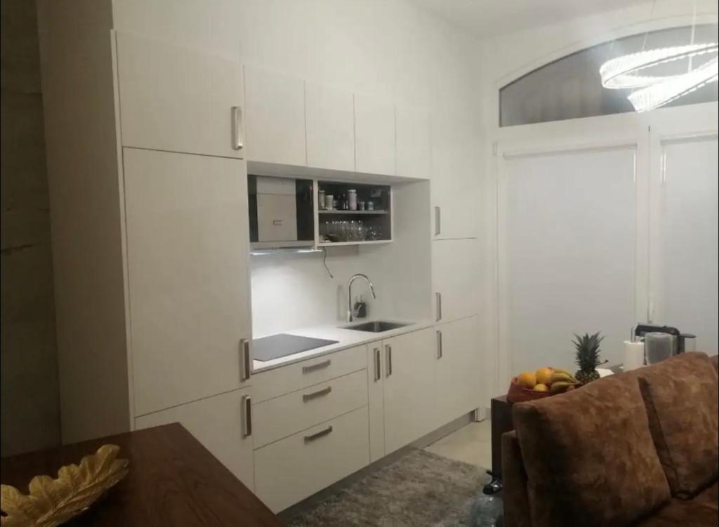 a kitchen with white cabinets and a sink at Cava do Viriato Apartamento in Viseu